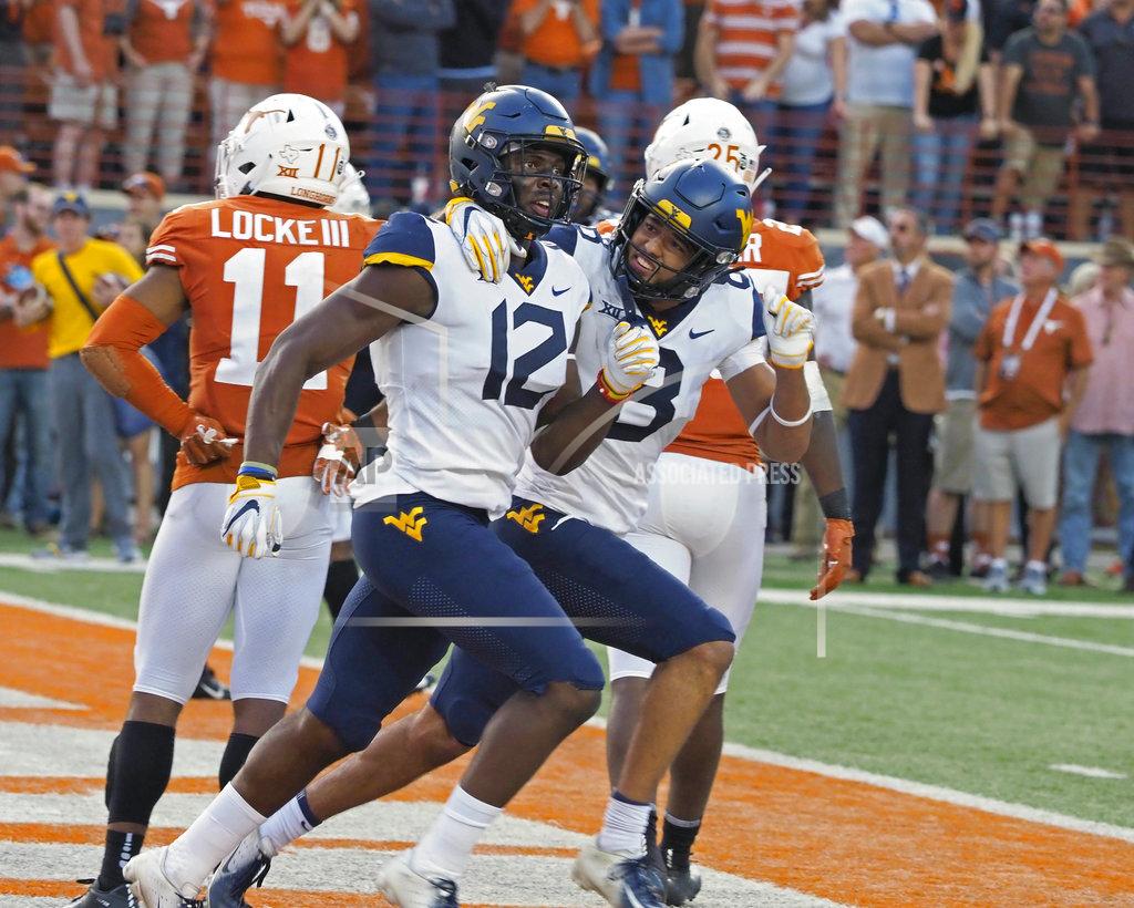 Michael Thomas West Virginia receiver Gary Jennings (12) and Marcus Simms (8) celebrate Jenning's touchdown catch during the second half of an NCAA college football game against Texas, Saturday, Nov. 3, 2018, in Austin, Texas. West Virginia won 42-41. (AP Photo/Michael Thomas)