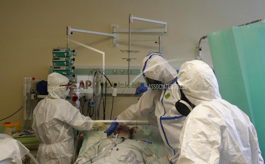 Petr David Josek Health care workers prepare to transport a COVID-19 patient from an intensive care unit (ICU) at hospital in Kyjov to hospital in Brno, Czech Republic, Thursday, Oct. 22, 2020. Coronavirus infections in the Czech Republic are on a steep rise, setting a new record high for the second straight day. About 4,500 COVID-19 patients have filled up the country's hospital with the government expected the health system will be overwhelmed by Nov 11 if the surge doesn't slow. (AP Photo/Petr David Josek)