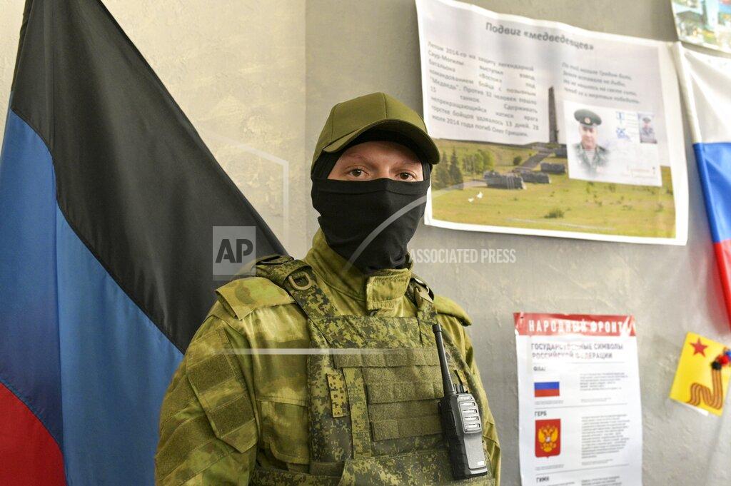 Uncredited A Donetsk People's Republic serviceman stands guard at a polling station prior to a referendum in Donetsk, Donetsk People's Republic, controlled by Russia-backed separatists, eastern Ukraine, Thursday, Sept. 22, 2022. Authorities in Russian-controlled regions in eastern and southern Ukraine are preparing to hold referendums on becoming part of Russia's a move that could allow Moscow to escalate the war. The votes start Friday in the Luhansk, Kherson and partly Russian-controlled Zaporizhzhia and Donetsk regions. (AP Photo)