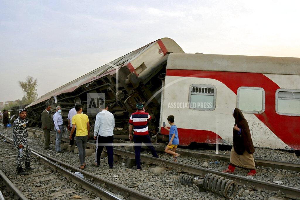 Fadel Dawood People gather at the site where a passenger train derailed injuring at least 100 people, near Banha, Qalyubia province, Egypt, Sunday, April 18, 2021. At least eight train wagons ran off the railway, the provincial governor's office said in a statement. (AP Photo/Fadel Dawood)