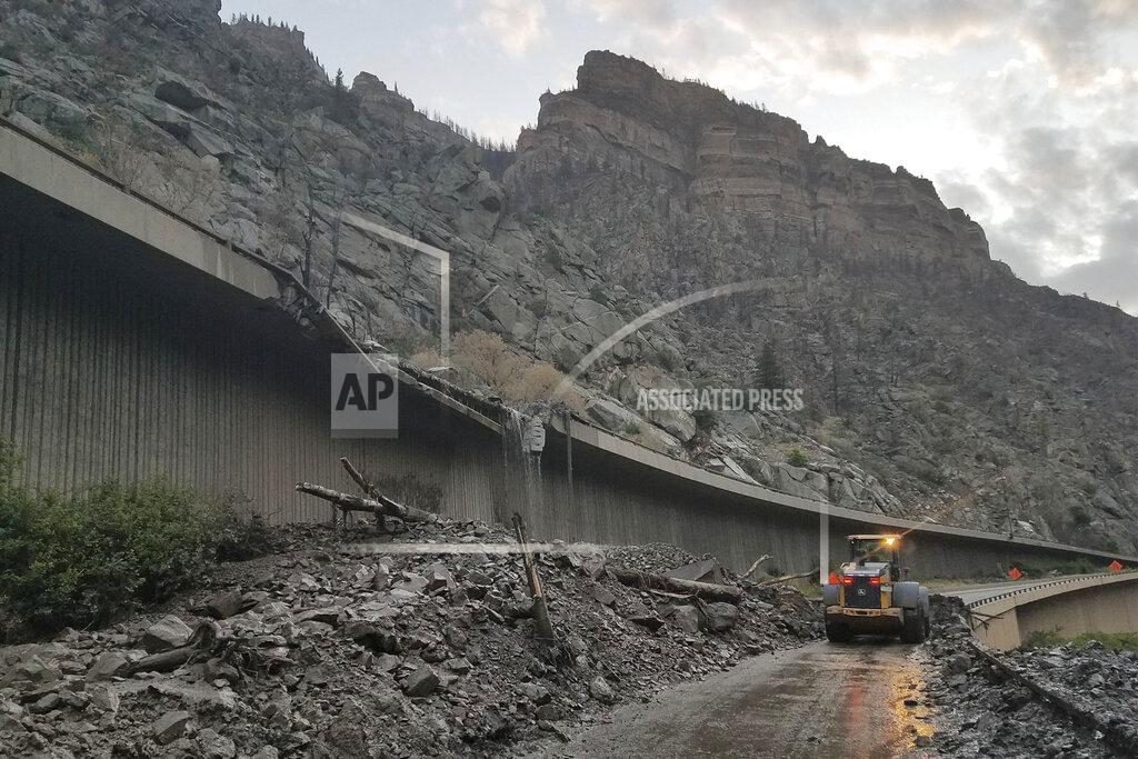 Uncredited In this photo provided by the Colorado Department of Transportation, equipment works to clear mud and debris from a mudslide on Interstate-70 through Glenwood Canyon, Colo., on Friday, July 30, 2021. Authorities say more than 100 people had to spend the night on the highway, including nearly 30 who took refuge inside a highway tunnel along I-70 in Glenwood Canyon after rain over an area burned by a wildfire triggered the mudslides in Western Colorado. The people were caught with their vehicles Thursday night, July 29, 2021 and it took crews nine hours to carve out a path through the mud to reach them about 6:30 a.m. Friday, Garfield County Sheriff's Office spokesman Walt Stowe said. (Colorado Department of Transportation via AP)