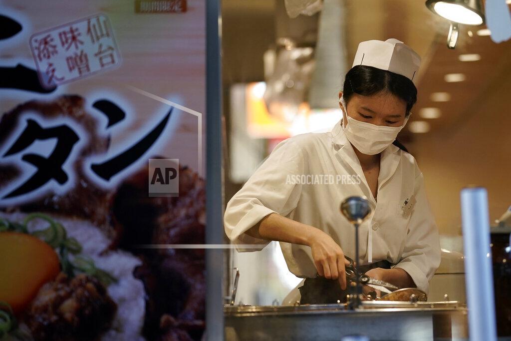 Eugene Hoshiko A restaurant employee wearing a face mask to help curb the spread of the coronavirus prepare a dish for a customer, Thursday, Sept. 10, 2020, in Tokyo. The Japanese capital confirmed more than 270 coronavirus cases on Thursday. (AP Photo/Eugene Hoshiko)