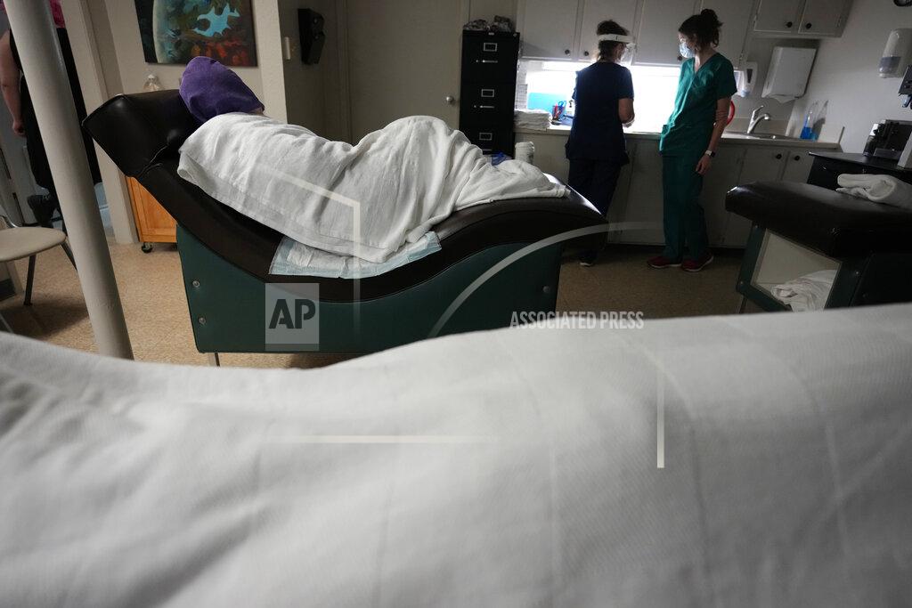 Rebecca Blackwell A woman naps, bundled up against the air conditioning, as she waits to have an abortion, Saturday, Oct. 9, 2021, at Hope Medical Group for Women in Shreveport, La. The nation's most restrictive abortion law is driving many women from Texas to seek services in neighboring states. The abortion clinic in Shreveport, is among the clinics being inundated. (AP Photo/Rebecca Blackwell)