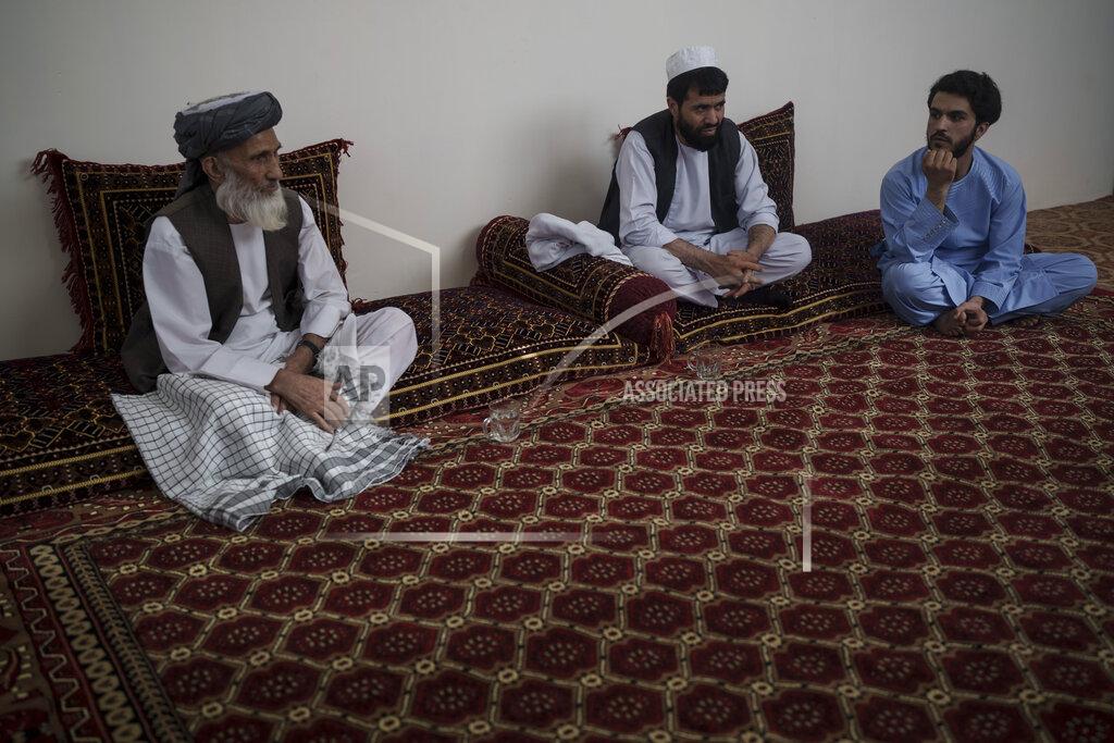 Felipe Dana Ghulam Ghous, left, sits with his sons Ghulam Zikria, center, and Zakir Anwari, in their home in Kabul, Afghanistan, Friday, Sept. 17, 2021. Ghous lost his other son Zaki Anwari, a 17-year-old soccer player, who died after trying to board a U.S. Air Force C-17 taking off from Kabul’s International Airport last month. (AP Photo/Felipe Dana)