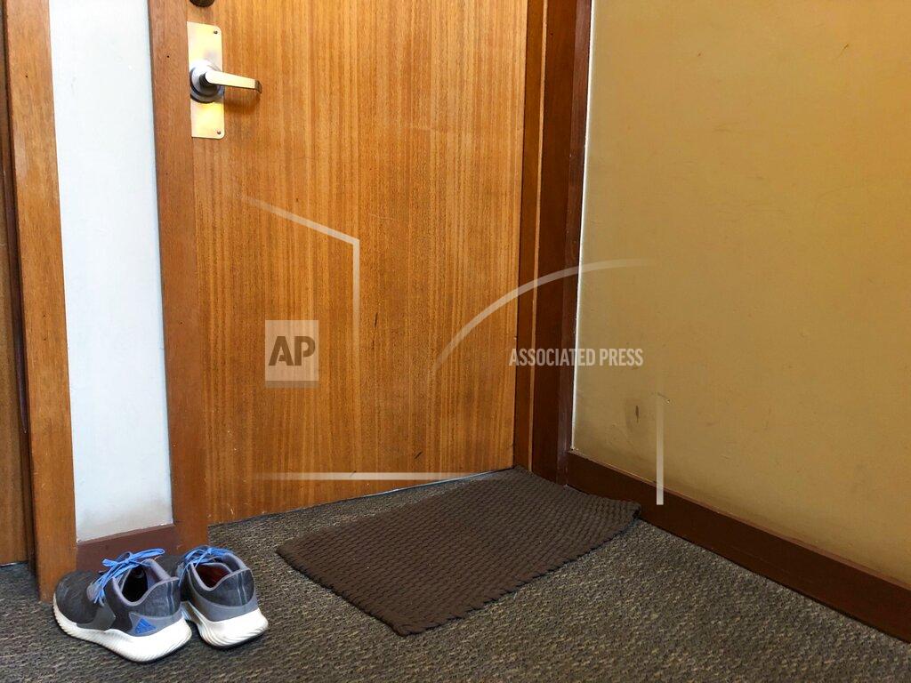 In this April 6, 2020, photo, shoes that are not allowed inside sit outside the door to Associated Press journalist Janelle Cogan's Atlanta home. Her boyfriend is an essential worker in the transportation sector, and because he's not able to work from home in the coronavirus outbreak, they take precautions, including leaving some belongings outside when he comes back in the evenings. (AP Photo/Janelle Cogan)