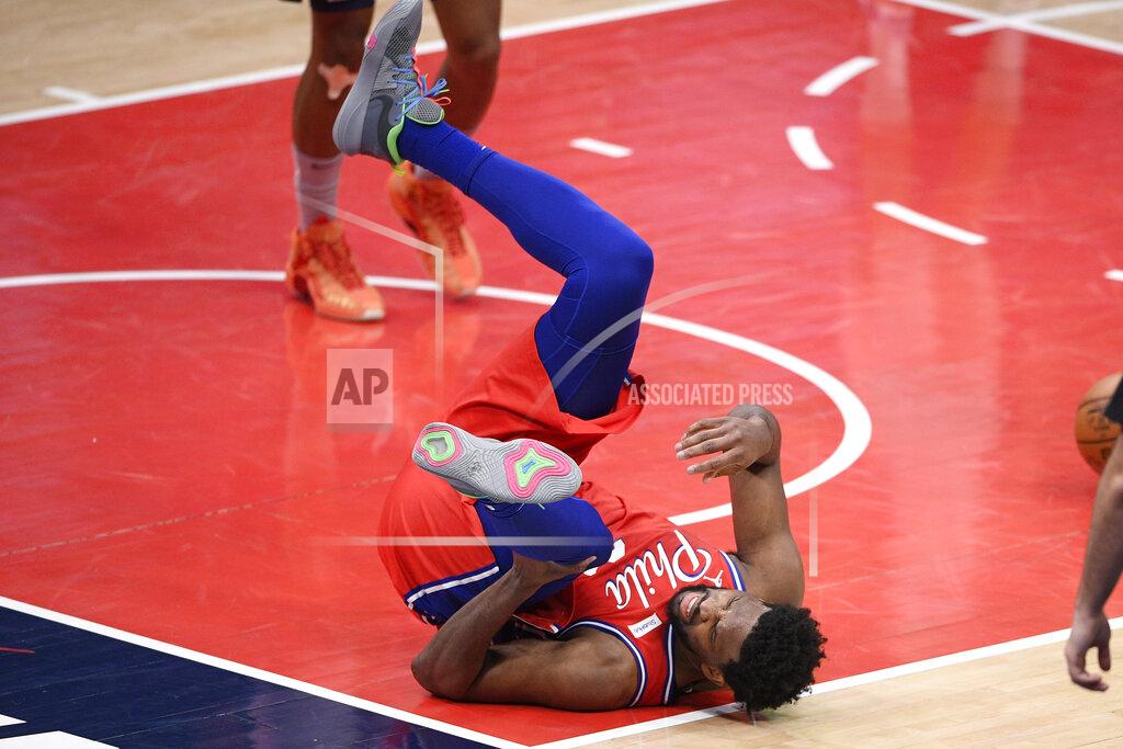 Nick Wass Philadelphia 76ers center Joel Embiid (21) grabs his knee after he was injured during the second half of the team's NBA basketball game against the Washington Wizards, Friday, March 12, 2021, in Washington. (AP Photo/Nick Wass)
