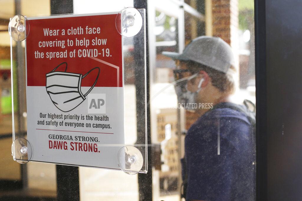 Joshua L. Jones A student, wearing a face mask, enters the school book store at the University of Georgia, Thursday, Aug. 20, 2020. in Athens, Ga. (Joshua L. Jones/Athens Banner-Herald via AP)