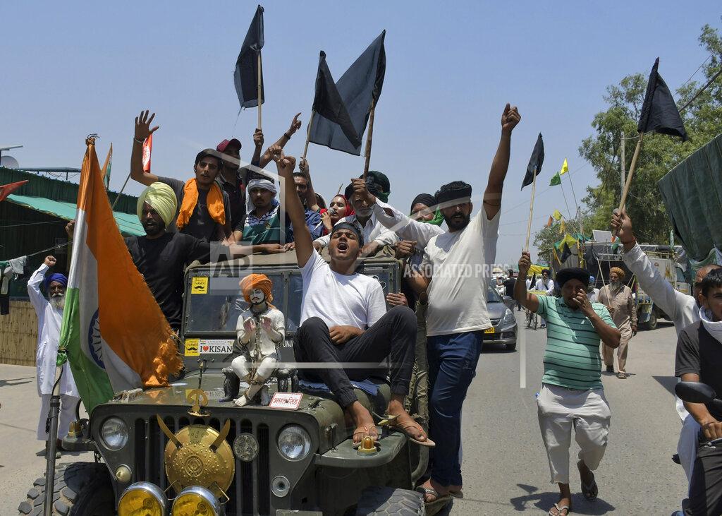 Ishant Chauhan Farmers, some carrying black flags, on a vehicle during a protest in Ghazipur, outskirts of New Delhi, India, Wednesday, May 26, 2021. Indian farmers demanding the government repeal new agriculture laws they say will devastate their livelihoods marked their protest movement's sixth month Wednesday by flying black banners on the cars and tractors and burning effigies of the prime minister. (AP Photo/Ishant Chauhan)