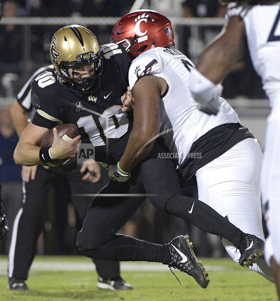 Phelan M. Ebenhack Central Florida quarterback McKenzie Milton (10) is sacked by Cincinnati defensive tackle Cortez Broughton during the first half of an NCAA college football game Saturday, Nov. 17, 2018, in Orlando, Fla. (AP Photo/Phelan M. Ebenhack)