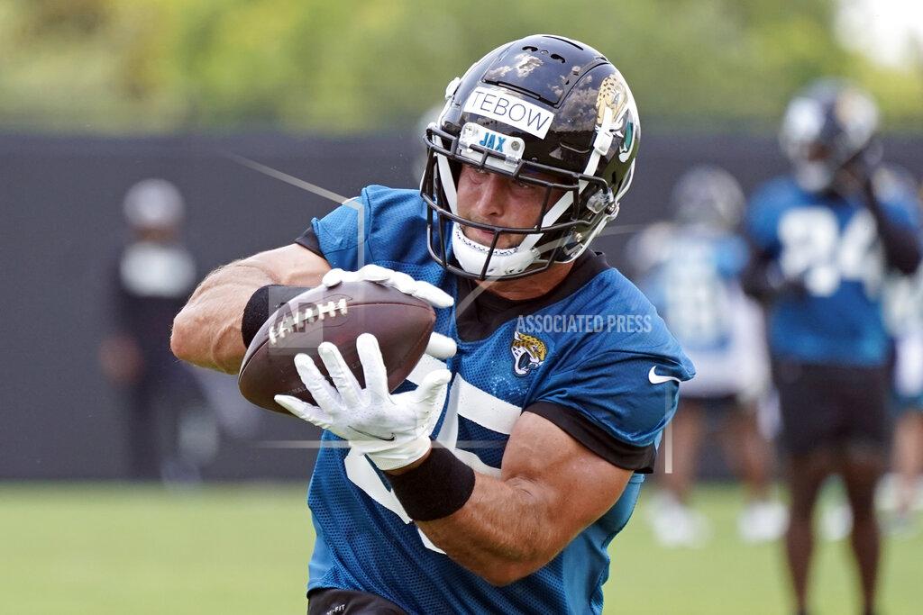 John Raoux FILE - Jacksonville Jaguars tight end Tim Tebow catches a pass during NFL football practice in Jacksonville, Fla., in this Thursday, May 27, 2021, file photo. Tebow’s far from the spotlight, right where coach Urban Meyer wants the 2007 Heisman Trophy winner for now. (AP Photo/John Raoux, File)