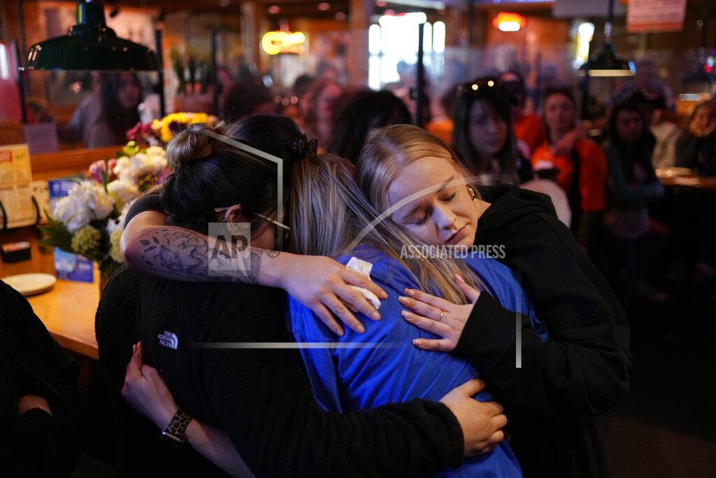 John Locher Emily Funderburk, right, embraces friends and coworkers during a memorial for Jackson Zinn at a Texas Roadhouse restaurant, Thursday, March 17, 2022, in Hobbs, New Mexico. Zinn, who worked at the restaurant, was killed with several other student golfers and the coach of University of the Southwest in a crash in Texas. (AP Photo/John Locher)