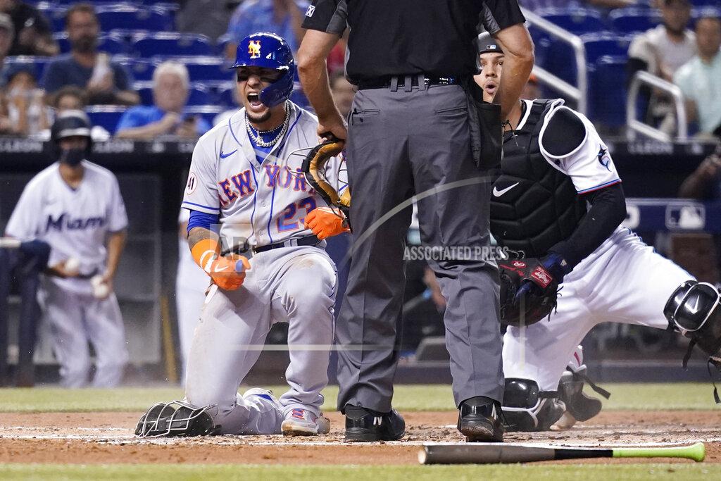 Lynne Sladky New York Mets' Javier Baez, left, reacts after scoring past Miami Marlins catcher Alex Jackson, right, during the second inning of a baseball game, Wednesday, Aug. 4, 2021, in Miami. (AP Photo/Lynne Sladky)