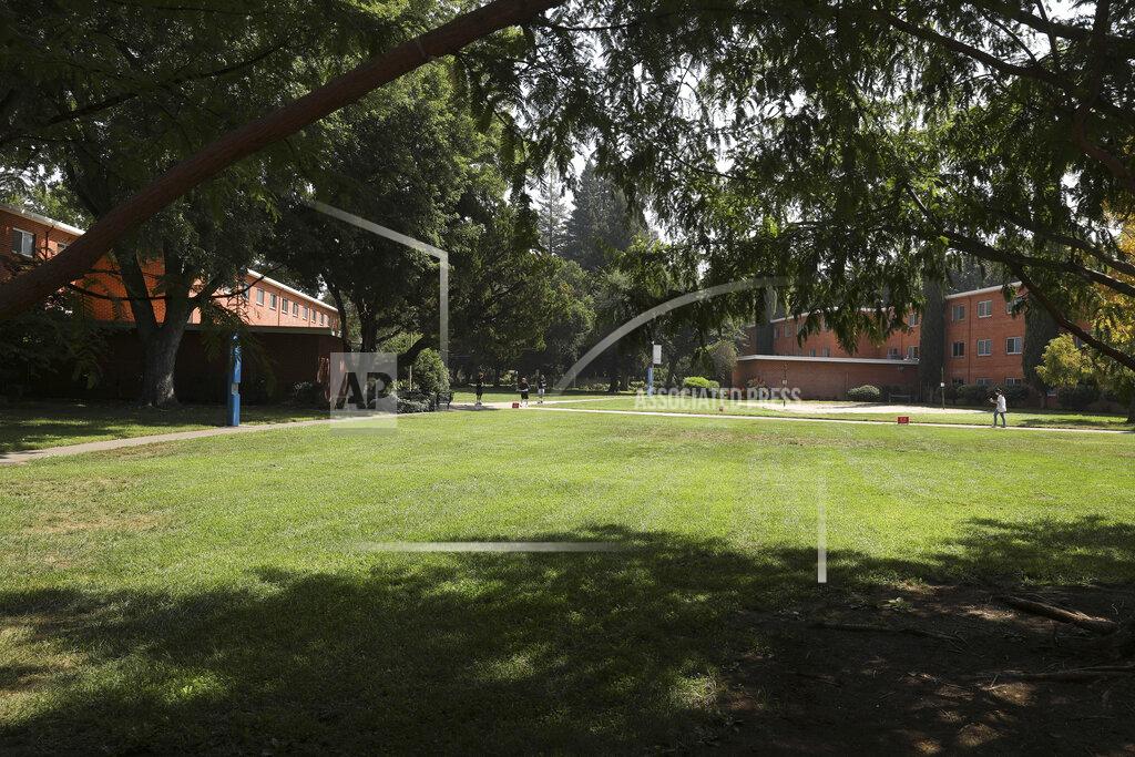 FILE - In this Aug. 31, 2020, file photo, people walk on the campus at California State University, Chico, in Chico, Calif. California State University, Chico said Tuesday, Sept. 1, 2020, it has no access to coronavirus test kits, despite requesting them for months, so is unable to screen for the virus on campus amid an outbreak that prompted it to abruptly halt in-person classes earlier in the week. (Carin Dorghalli/The Chico Enterprise-Record via AP, File)