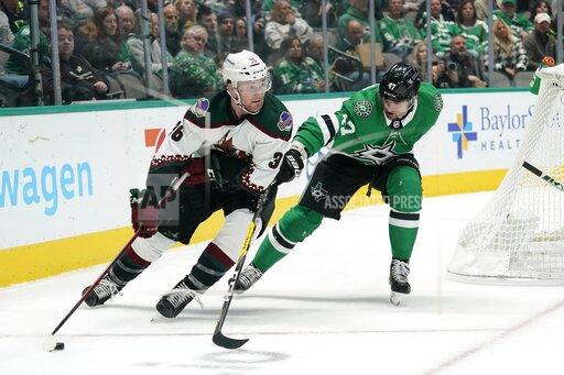 Arizona Coyotes right wing Christian Fischer (36) looks to make a pass as Dallas Stars right wing Alexander Radulov (47) defends in the second period of an NHL hockey game in Dallas, Monday, Dec. 6, 2021. (AP Photo/Tony Gutierrez)