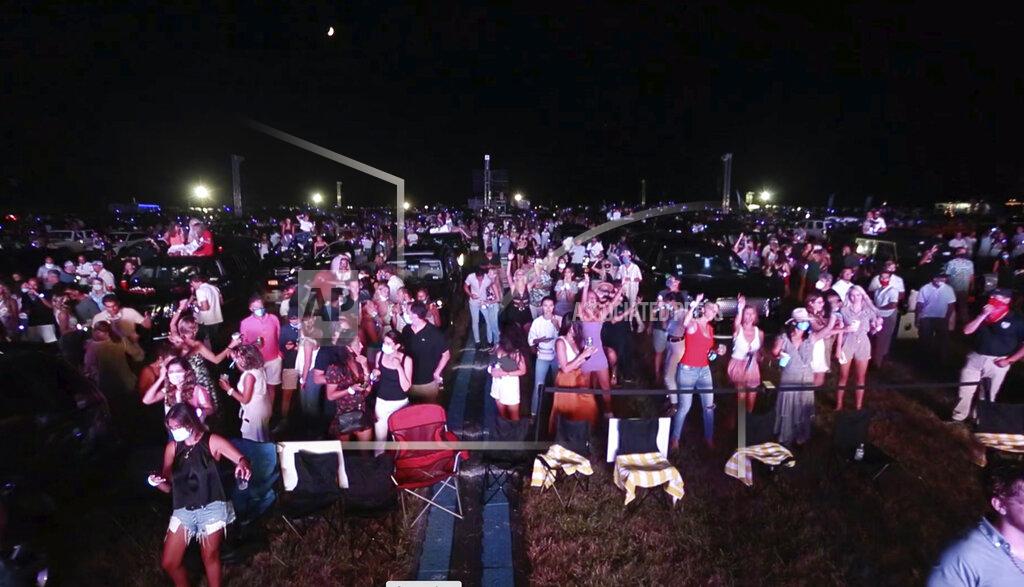 Rich Schineller In this July 25, 2020, image made from video provided by Rich Schineller, large groups of young people stand close to one another, many without wearing any face covering, at the "Safe & Sound" concert in Southhampton, N.Y. New York Gov. Andrew Cuomo says he is "appalled" by videos showing crowds standing close together at a Hamptons concert featuring electronic music duo The Chainsmokers over the weekend. Cuomo went on to say that the state Department of Health will conduct an investigation into "egregious social distancing violations." (Rich Schineller via AP)