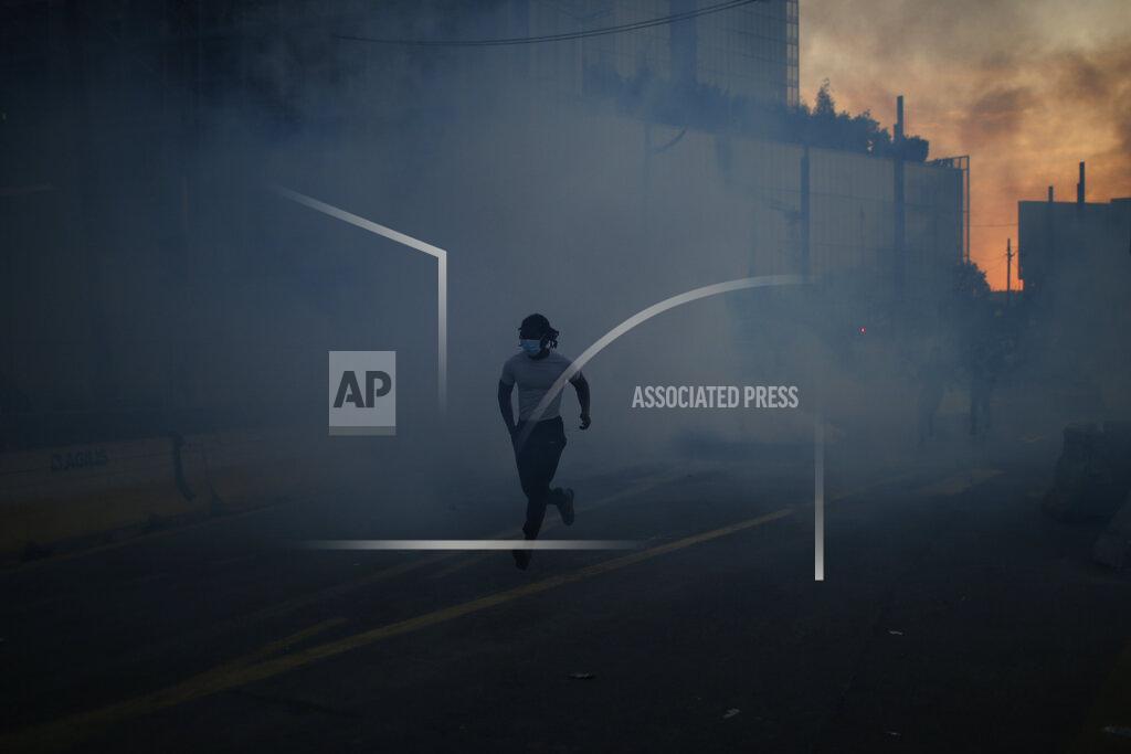 Rafael Yaghobzadeh A protesters runs through tear gas during a demonstration Tuesday, June 2, 2020. Paris riot officers fired tear gas as scattered protesters threw projectiles and set fires at an unauthorized demonstration against police violence and racial injustice. Several thousand people rallied peacefully for two hours around the main Paris courthouse in homage to George Floyd and to Adama Traore, a French black man who died in police custody. (AP Photo/Rafael Yaghobzadeh)