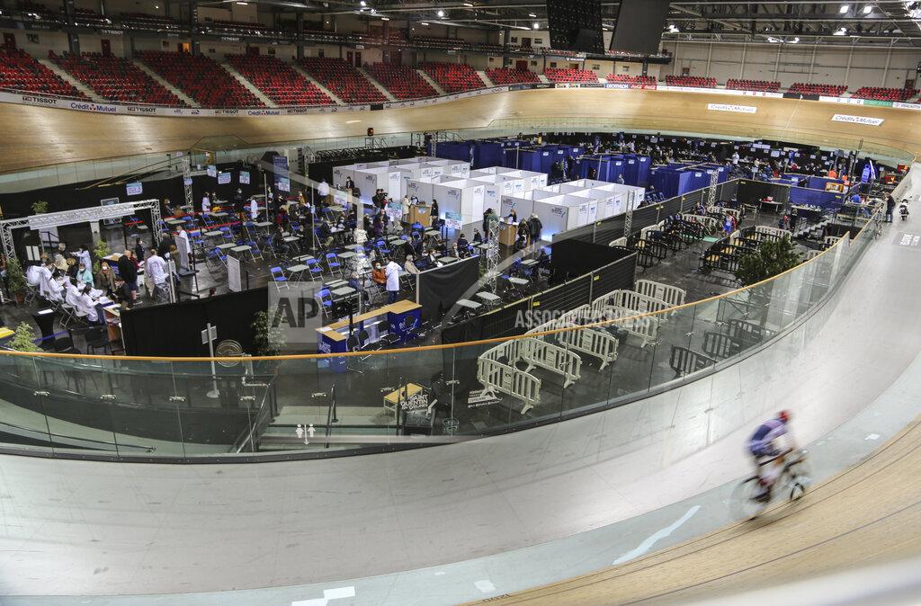 John Leicester A riders trains at the National Velodrome at Saint-Quentin-en-Yvelines, west of Paris, Saturday, March 27, 2021, that has been transformed into a mass vaccination center. Saturday marked the first day in France of vaccination for healthy people aged 70 and above. (AP Photo/John Leicester)