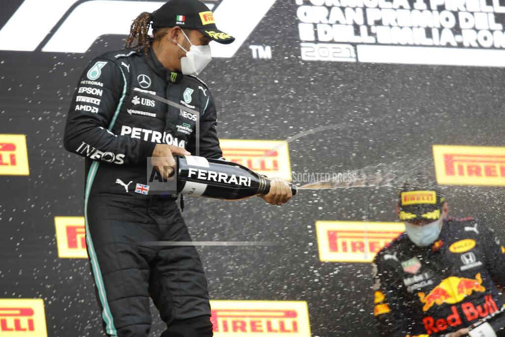 Luca Bruno Second placed Mercedes driver Lewis Hamilton of Britain sprays sparkling wine on winner Red Bull driver Max Verstappen of the Netherlands, after the Emilia Romagna Formula One Grand Prix, at the Imola racetrack, Italy, Sunday, April 18, 2021. (AP Photo/Luca Bruno)