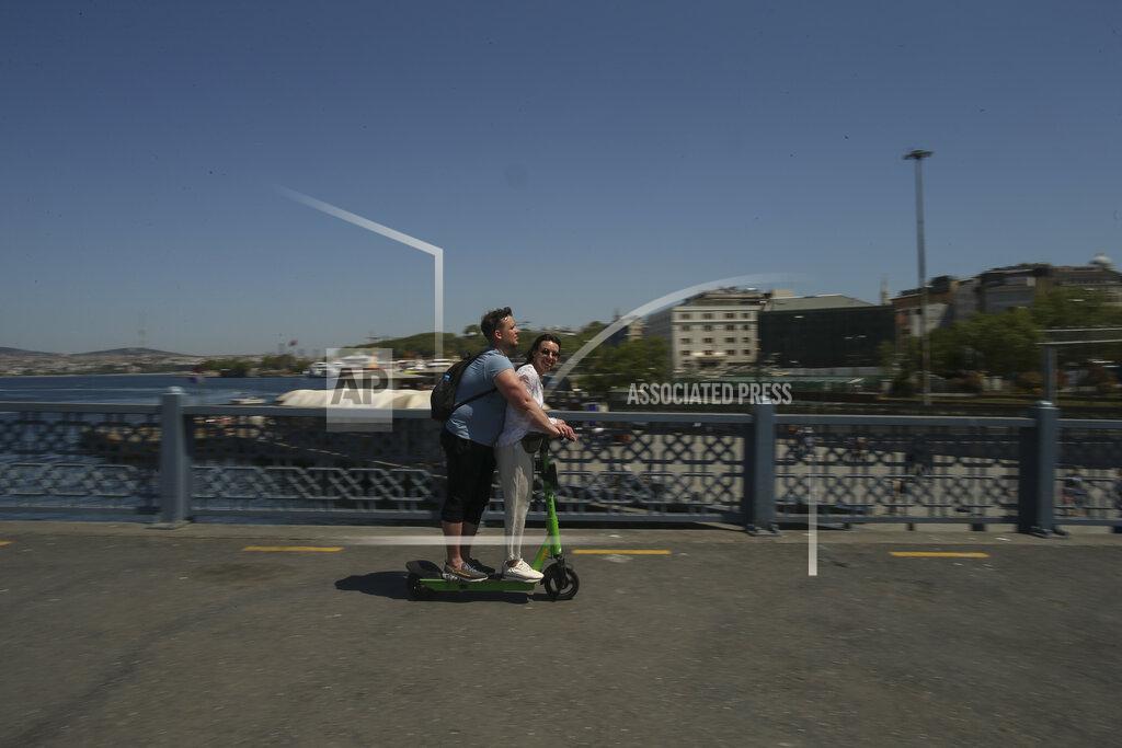 Emrah Gurel People ride a scooter on the Galata Bridge over the Golden Horn in Istanbul, Friday, May 14, 2021.Turkey is in the final days of a full coronavirus lockdown and the government has ordered people to stay home and businesses to close amid a huge surge in new daily infections. But millions of workers are exempt and so are foreign tourists. Turkey is courting international tourists during an economic downturn and needs the foreign currencies that tourism brings to help the economy as the Turkish lira continues to sink. (AP Photo/Emrah Gurel)