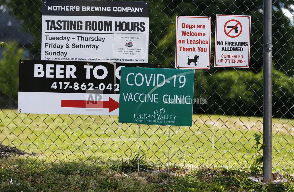 Nathan Papes Signs hang on a fence for Mother's Brewing Company's COVID-19 vaccine clinic in partnership with the Springfield-Greene County Health Department and Jordan Valley Community Health Center on Tuesday, June 22, 2021, in Springfield, Mo. As the U.S. emerges from the COVID-19 crisis, Missouri is becoming a cautionary tale for the rest of the country: It is seeing an alarming rise in cases because of a combination of the fast-spreading delta variant and stubborn resistance among many people to getting vaccinated. (Nathan Papes/The Springfield News-Leader via AP)