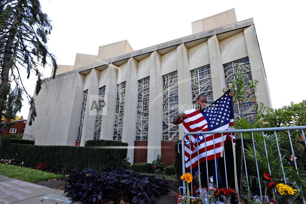 Gene J. Puskar A man places an American flag outside the Tree of Life synagogue in Pittsburgh on Sunday, Oct. 27, 2019, the first anniversary of the shooting at the synagogue that killed 11 worshippers. (AP Photo/Gene J. Puskar)