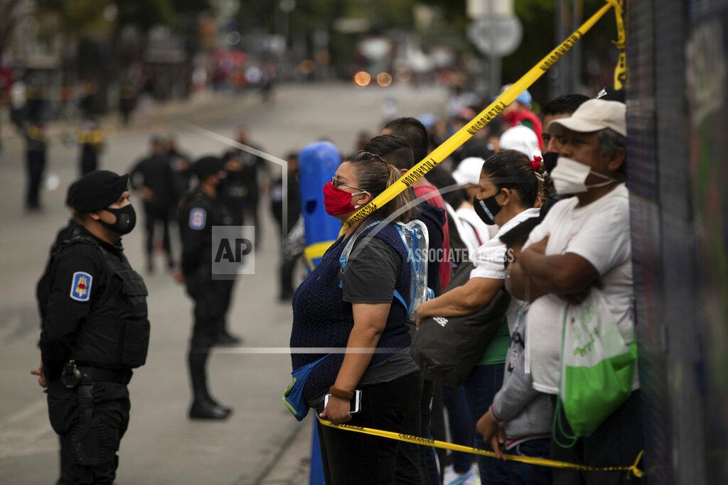 Fernando Llano Spectators take position near the perimeter to where the annual Independence Day military parade will pass on Mexico City’s Juarez Avenue, Wednesday, Sept. 16, 2020. Mexico celebrates the anniversary of its independence uprising of 1810. (AP Photo/Fernando Llano)