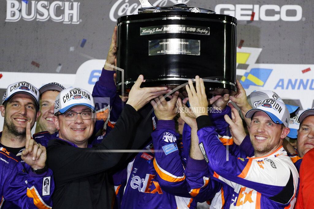 Terry Renna Denny Hamlin, right, celebrates as he and crew members hoist the championship trophy after winning the NASCAR Daytona 500 auto race at Daytona International Speedway, Monday, Feb. 17, 2020, in Daytona Beach, Fla. (AP Photo/Terry Renna)