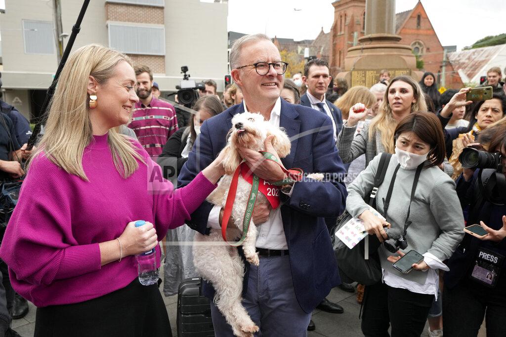 Rick Rycroft Labor Party leader Anthony Albanese holds his dog, Toto, after he and his partner Jodie Haydon, left, voted in Sydney, Australia, Saturday, May 21, 2022. Australians go to the polls following a six-week election campaign that has focused on pandemic-fueled inflation, climate change and fears of a Chinese military outpost being established less than 1,200 miles off Australia's shore. (AP Photo/Rick Rycroft)