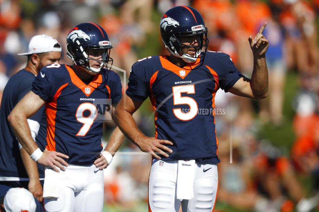 David Zalubowski Denver Broncos quarterback Joe Flacco, right, directs an end during drills as backup quarterback Kevin Hogan looks on an NFL football training camp session Monday, Aug. 5, 2019, in Englewood, Colo. (AP Photo/David Zalubowski)