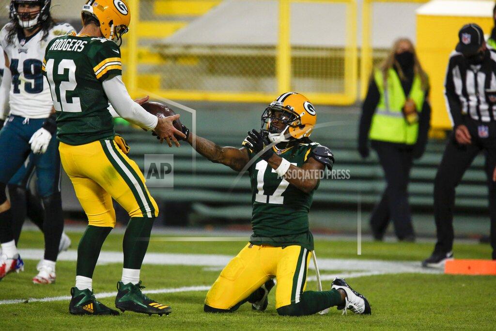 Matt Ludtke Green Bay Packers' Davante Adams gives quarterback Aaron Rodgers the ball after catching a touchdown pass during the second half of an NFL football game against the Philadelphia Eagles Sunday, Dec. 6, 2020, in Green Bay, Wis. (AP Photo/Matt Ludtke)