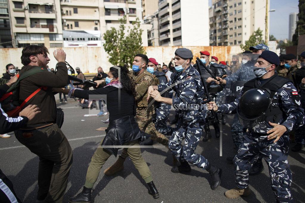 Hassan Ammar Riot police and army soldiers scuffle with anti-government protesters outside a military court in Beirut, Lebanon, Monday, Feb. 8, 2021. Riot police briefly clashed Monday in Beirut with hundreds of protesters demanding the release of anti-government activists detained following riots in northern Lebanon late last month. (AP Photo/Hassan Ammar)