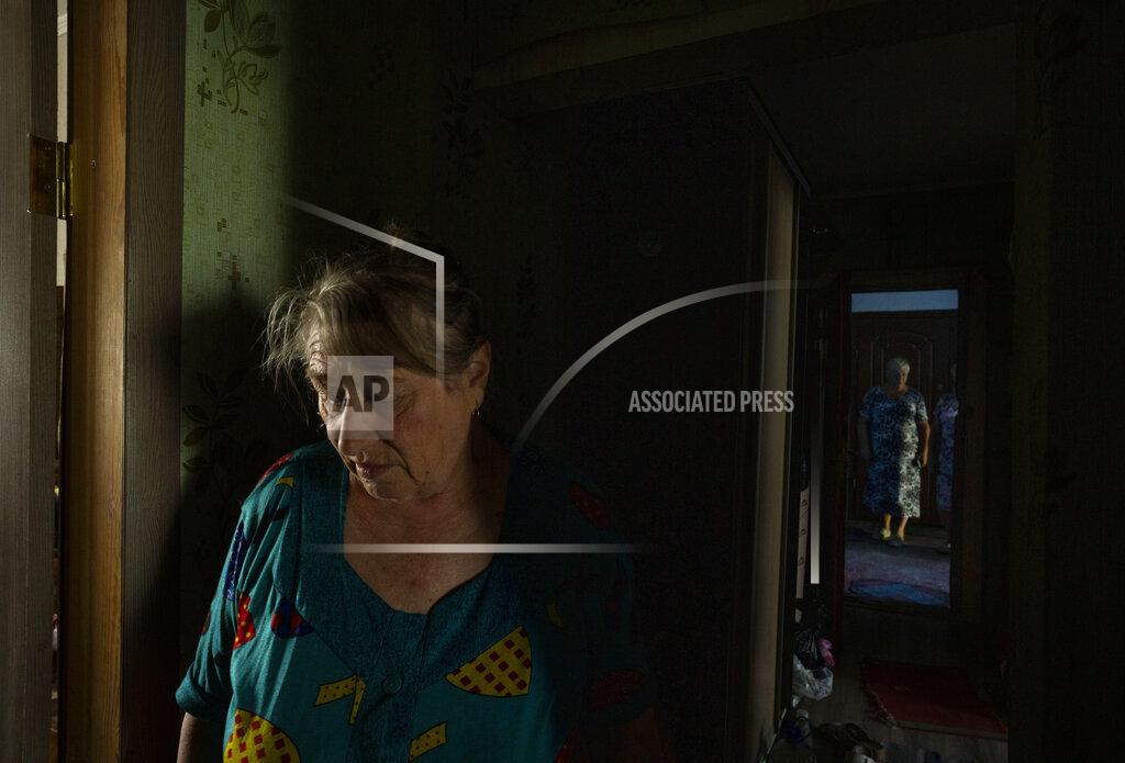 Nariman El-Mofty 70-year-old Valentyna Klymenko, who lives alone in her war-damaged building from Russian aerial bombs, walks in her hallway, in Borodyanka, Kyiv region, Ukraine, Tuesday, June 28, 2022. Then Klymenko returns, alone, to an apartment that used to be noisy and full of life. Now, instead of the voices of her great-grandchildren, she is greeted by dim, damp rooms. She rarely cooks. She drinks fruit compote and eats canned tomatoes, which she prepared last year, so as not to waste the gas in her portable stove. (AP Photo/Nariman El-Mofty)