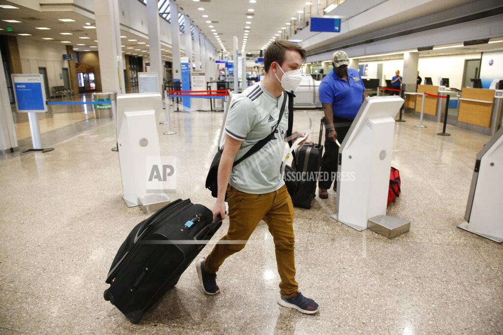 FILE - In this April 30, 2020, file photo, Ethan Cale walks to the American Airlines ticket counter in Salt Lake City. American Airlines is telling 25,000 workers that they could lose their jobs in October because of the sharp drop in air travel during the virus pandemic. The airline said Wednesday, July 15, it was starting new offers of buyouts and partially paid leave, which it hopes will reduce the number of furloughs. (AP Photo/Rick Bowmer, File)