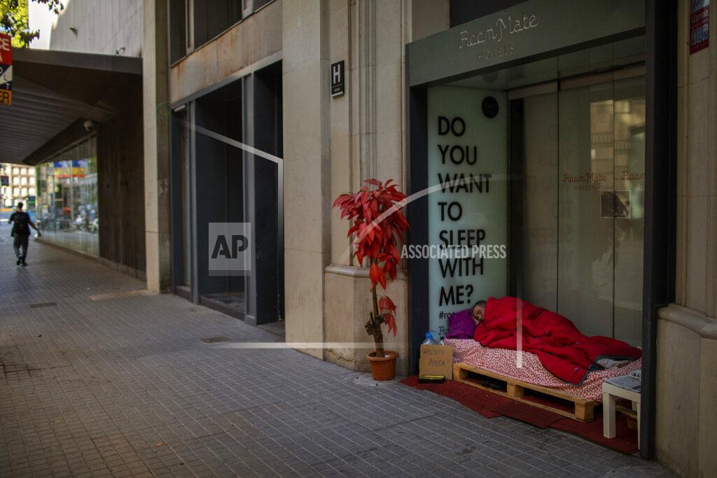 Emilio Morenatti Reduan Elhammoudani, 45, from Syria, sleeps in a hotel entrance, closed during the coronavirus outbreak in Barcelona, Spain, Saturday, June 6, 2020. Reduan fled Syria seven years ago, after his wife and two children, 3 and 7, were killed in a bombing during the war. Since the confinement began due to the coronavirus outbreak, Reduan has subsisted thanks to the charity of the neighbourhood residents. (AP Photo/Emilio Morenatti)