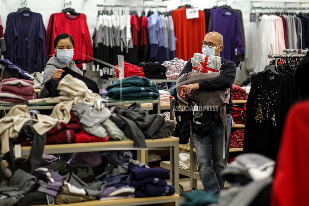 Ringo H.w. Chiu Black Friday shopper Alex Gamboa, right, 58, of Los Angeles, holds merchandises as his wife, who did not give her name, checks the bargains at the Glendale Galleria in Glendale, Calif., Friday, Nov. 27, 2020. (AP Photo/Ringo H.W. Chiu)