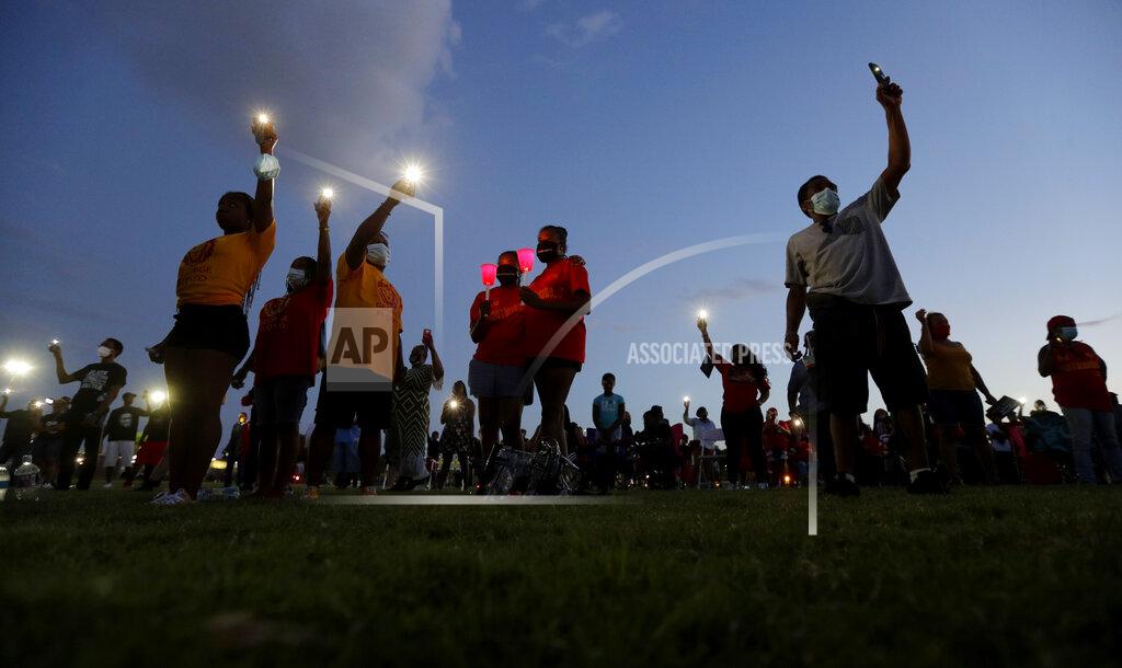 FILE - In this Monday, June 8, 2020, file photo, local residents and alumni of Jack Yates High School take part in a candlelight vigil to honor George Floyd, in Houston. Floyd died after being restrained by Minneapolis Police officers on May 25. As the trial surrounding the death of Floyd begins in Minneapolis, a sweeping package of police reforms in his native Texas has scarce signs of early support within the state’s GOP majority. The “George Floyd Act” was scheduled to get its first hearing in the Texas Capitol on Thursday, March 25, 2021. (AP Photo/Eric Gay, File)