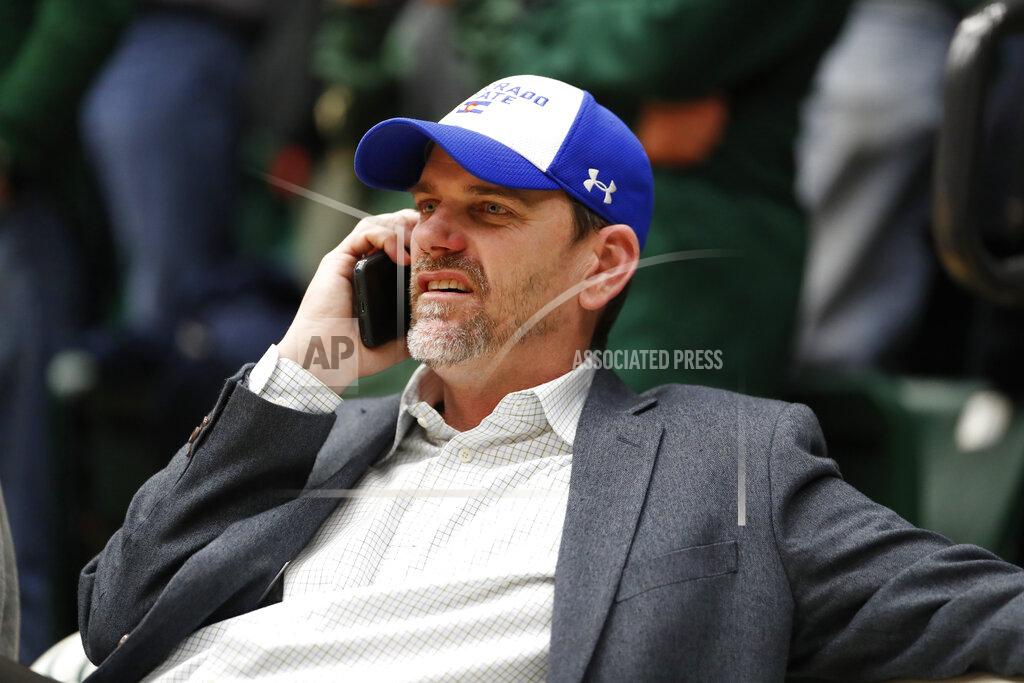 FILE - In this Feb. 6, 2019, file photo, Colorado State football coach Mike Bobo chats on his mobile phone while seated at an NCAA college basketball game between Nevada and Colorado State in Fort Collins, Colo. Bobo preaches toughness and accountability. He demonstrated that toughness last season by walking the sidelined despite fighting a rare autoimmune disease that caused him to lose sensation in both feet. He showed accountability by declining a $100,000 pay increase due to him after the Rams struggled to a 3-9 record in 2018. That's why his messages hit home. (AP Photo/David Zalubowski, File)