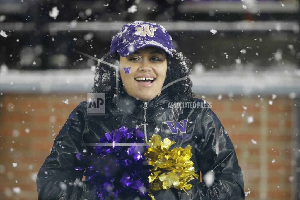 Ted S. Warren A Washington cheerleader stands, with snow on her hair and ball cap, during the second half of the team's NCAA college football game against Washington State, Friday, Nov. 23, 2018, in Pullman, Wash. Washington won 28-15. (AP Photo/Ted S. Warren)