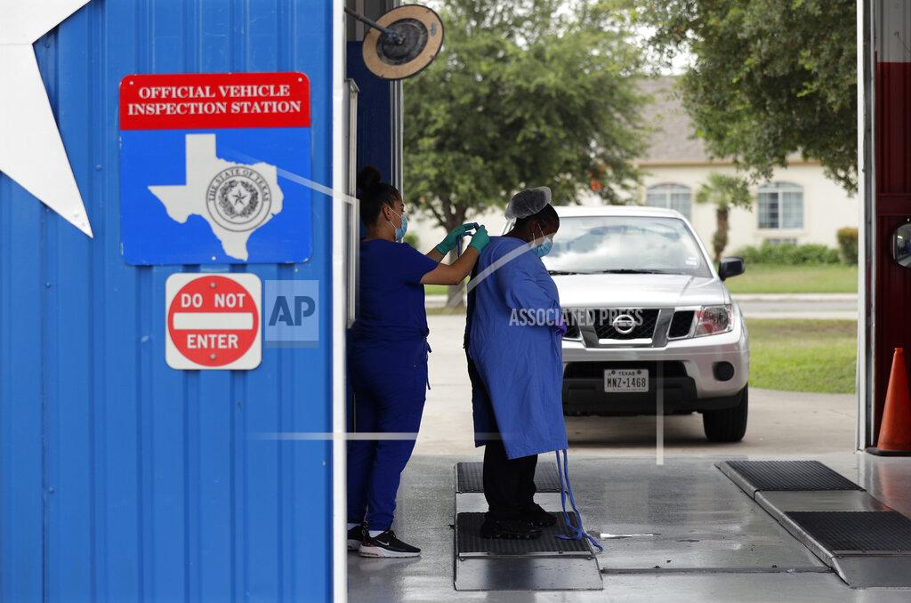 Eric Gay Medical workers suit up with protective personal equipment as they prepare to administer COVID-19 antibody tests and diagnostic tests at a converted vehicle inspection station, Tuesday, July 7, 2020, in San Antonio. Local officials across Texas say their hospitals are becoming increasingly stretched and are in danger of becoming overrun as cases of the coronavirus surge. (AP Photo/Eric Gay)