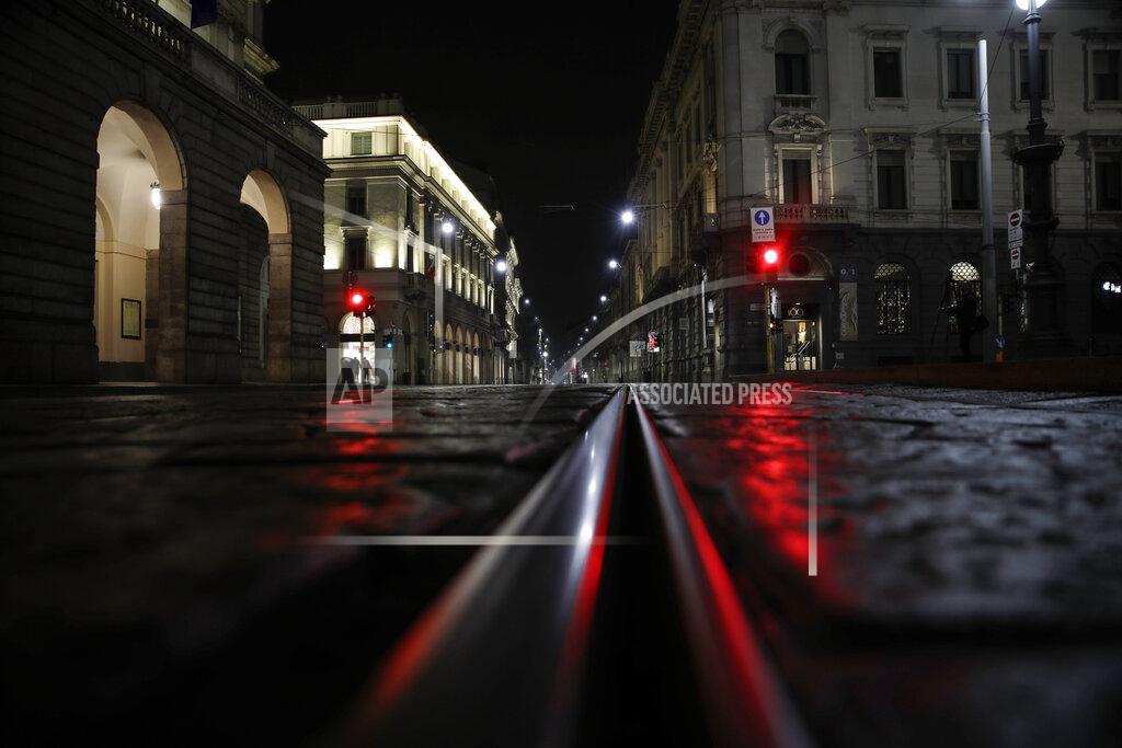 Luca Bruno Light reflects off the cobblestones of an empty street next to La Scala theater, left, early Sunday, Oct. 25, 2020. On its second night of curfew, Milan's main streets and piazzas remained empty. The financial capital of the country had also been known for its bustling night life. (AP Photo/Luca Bruno)