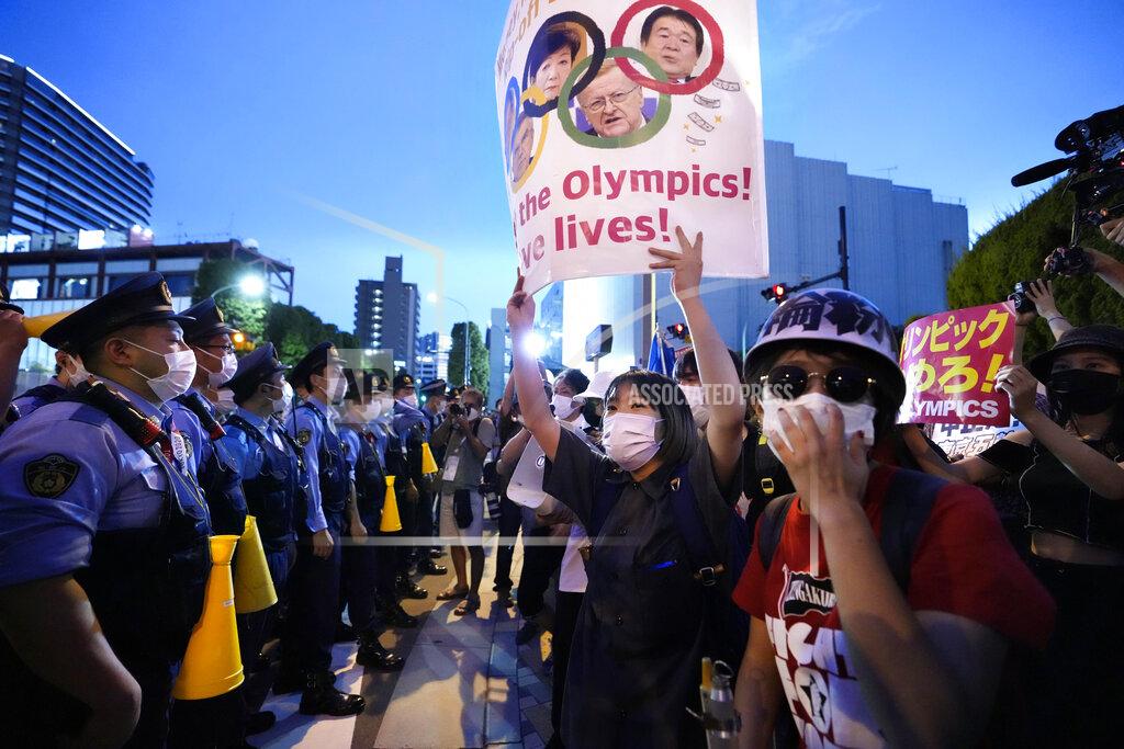Ryosuke Uematsu Anti-Olympics protesters, right, stage a rally in front of lines of policemen near National Stadium in Tokyo Friday, July 23, 2021. (Ryosuke Uematsu/Kyodo News via AP)