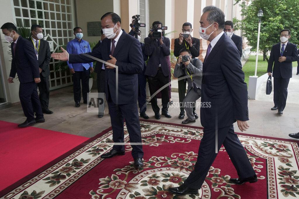 Kith Serey Chinese Foreign Minister Wang Yi, foreground right, is guided by his Cambodian counterpart Prak Sokhonn, center, in Phnom Penh, Cambodia, Sunday, Sept. 12, 2021. Wang is visiting Cambodia, where's he expected to meet with Prime Minister Hun Sen and other officials to discuss COVID-19 and other regional issues. (Kith Serey/Photo Photo via AP)