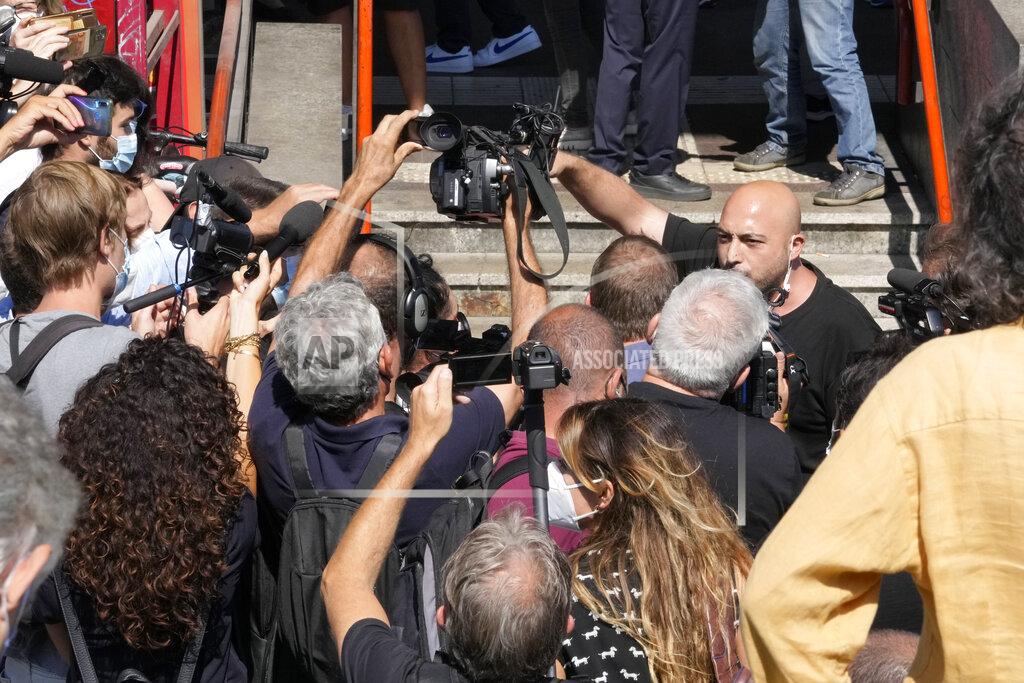 Luca Bruno A demonstrator, right, shouts to reporters in Stazione Centrale central train station, Wednesday, Sept. 2, 2021, in Milan, Italy. Italy's government vowed to crack down on demonstrators threatening to block train tracks throughout the country Wednesday as a rule requiring COVID-19 tests or vaccines to use public transportation for long-distance domestic travel took effect. (AP Photo/Luca Bruno)