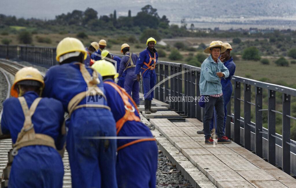 Ben Curtis FILE - In this Wednesday, Nov. 23, 2016 file photo, Kenyan laborers and a Chinese foreman, right, work to finish the construction of an existing bridge that goes across a corner of Nairobi National Park in Nairobi, Kenya. African leaders in 2020 are asking what China can do for them as the coronavirus pandemic threatens to destroy economies across a continent where Beijing is both the top trading partner and top lender. (AP Photo/Ben Curtis, File)