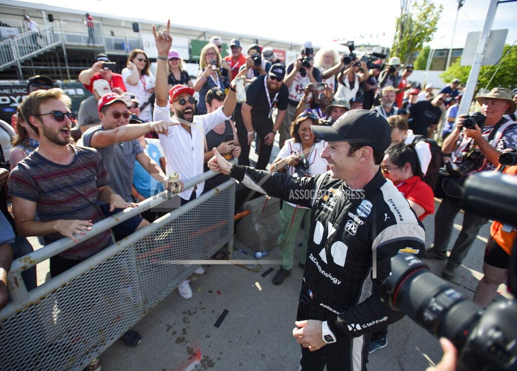 Andrew Lahodynskyj Simon Pagenaud, right, of France, celebrates with fans after winning the Honda Indy auto race in Toronto, Sunday, July 14, 2019. (Andrew Lahodynskyj/The Canadian Press via AP)