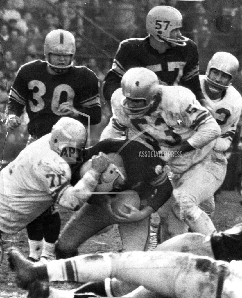 Uncredited FILE- Detroit Lions defensive tackle Alex Karras (71) helps with the tackle of an unidentified Pittsburgh Steelers football player in Pittsburgh, in this Nov. 8, 1959, file photo. A dozen seasons as one of the most feared pass-rushers in the NFL turned out to be just an opening act for Alex Karras. The Lions' four-time Pro Bowl star was a natural in front of the camera, whether crumpling quarterbacks, needling then-commissioner Pete Rozelle or sharing stories with Johnny Carson on “The Tonight Show.” Karras used that tough-guy image to launch a second career as a sportscaster, and a sitcom and movie star. (The Detroit News via AP)