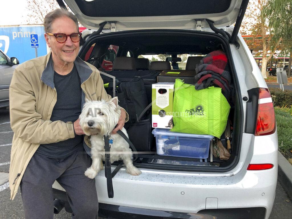 Adam Beam Matt Frinzi, 68, poses with his dog, Whitey, and his car filled with his belongings, in West Sacramento, California, on Tuesday, Dec. 15, 2020. Prinzi has lived in California for 25 years. But Tuesday he officially moved to Reno, Nevada. He said his quality of life has deteriorated so much in California that he wanted to leave. California saw its slowest growth rate on record for the nation's most populous state, adding just 21,200 people during the year that ended in July, state officials said Wednesday, Dec. 16, 2020. (AP Photo/Adam Beam)
