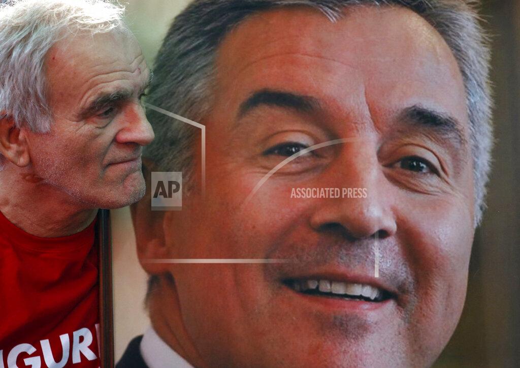 Darko Vojinovic FILE - In this Monday, Oct. 17, 2016 file photo, a supporter of long-ruling Democratic Party of Socialists leader Milo Djukanovic holds his portrait during celebration after parliamentary elections, in Podgorica, Montenegro. Montenegro's President Milo Djukanovic says the upcoming parliamentary vote is crucial in the defense of the small Balkan country's independence in the face of renewed attempts from Serbia and Russia to install their nationalist and anti-Western allies to power. (AP Photo/Darko Vojinovic, File)