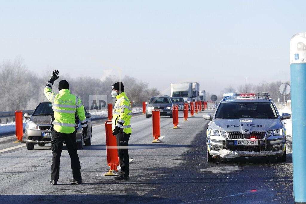 Petr David Josek Policemen stop a car to check documents of a driver near the city of Sokolov, Czech Republic, Friday, Feb. 12, 2021. Almost 600 police officers were deployed to enforce a complete lockdown of the three hardest-hit counties on the border with Germany and Poland to help contain a fast-spreading variant of the coronavirus found in Britain. (AP Photo/Petr David Josek)