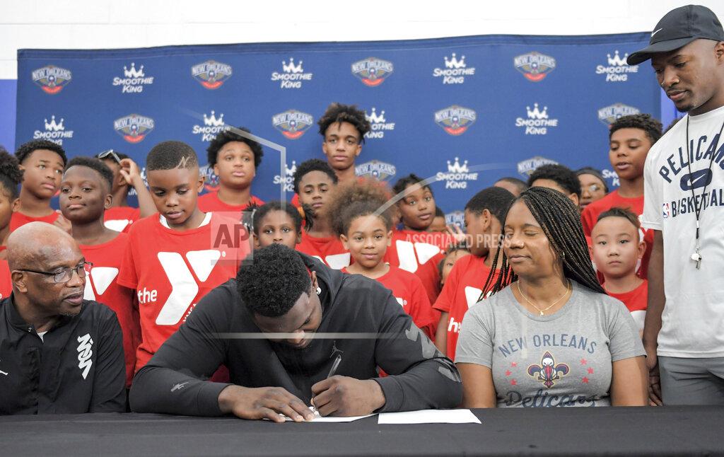 Max Becherer New Orleans Pelicans forward Zion Williamson, center, signs his contract extension surrounded by his family and children attending camp at the Dryades YMCA in New Orleans, Wednesday, July 6, 2022. (Max Becherer/The Times-Picayune/The New Orleans Advocate via AP)
